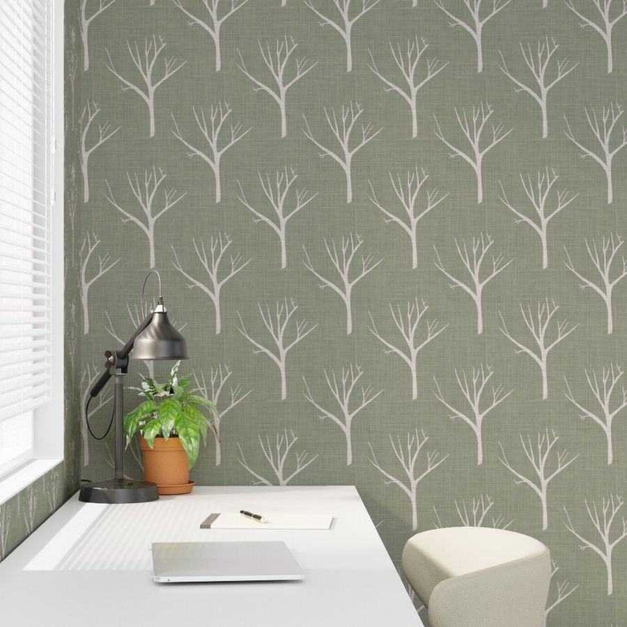 Wallpaper with tree pattern in a room with a desk and lamp.