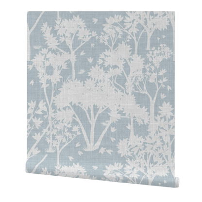 partially rolled wallpaper with a light garden pattern on a light blue background